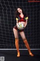 A woman in a soccer uniform holding a soccer ball.