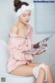 A woman sitting on a toilet reading a magazine.