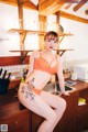 A woman sitting on top of a kitchen counter next to a sink.