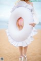 A woman in a white dress holding a white inflatable ring.